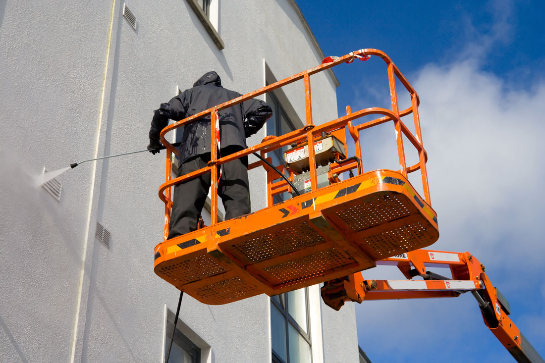 Pressure washing a commercial building facade
